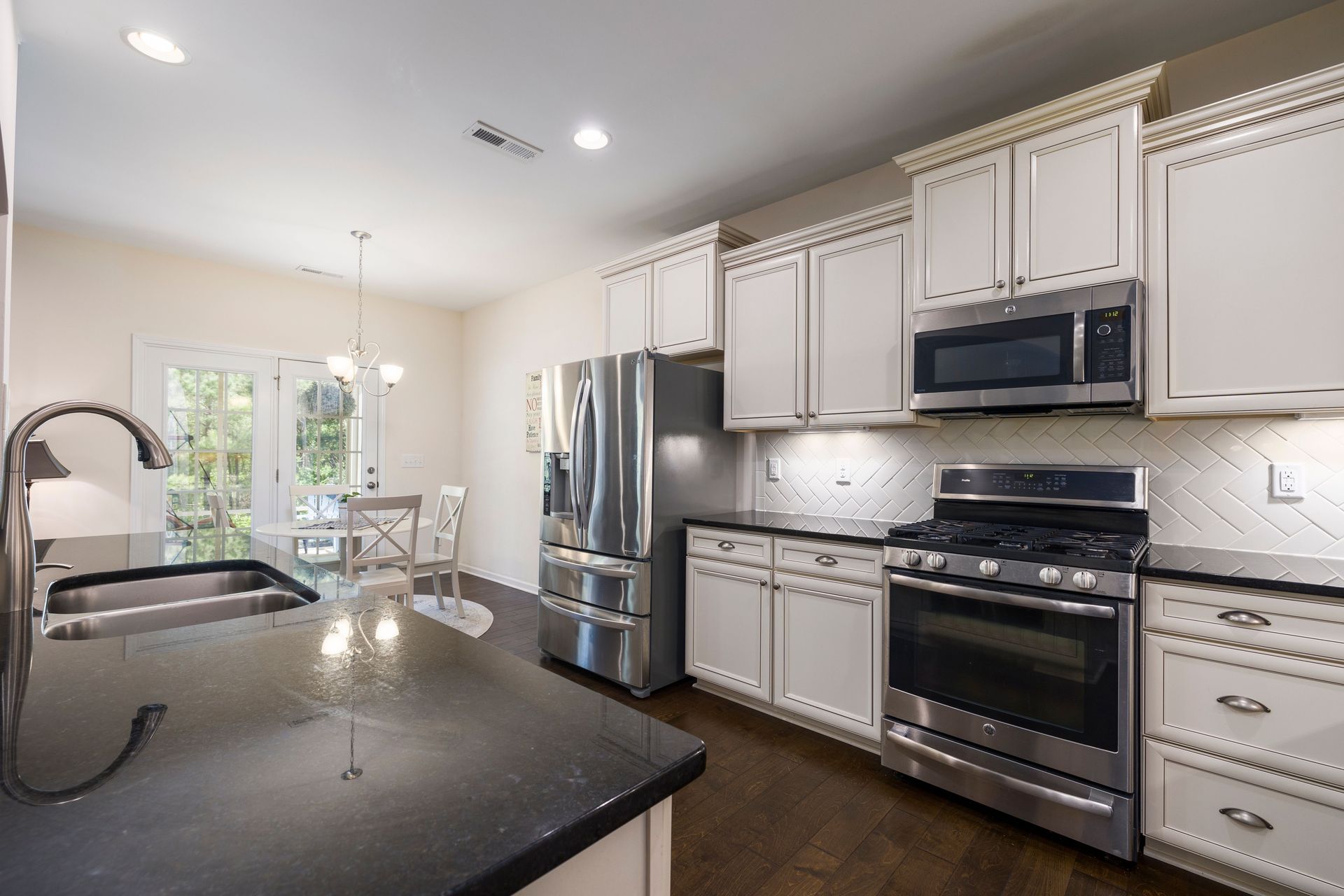 Bright modern kitchen featuring stainless steel appliances and dark countertops.